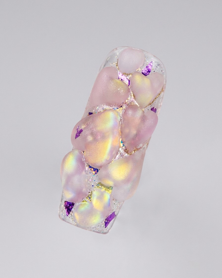 Une disposition complète de plusieurs cœurs 3D en acrylique iridescent couvrant la surface dun ongle allongé.