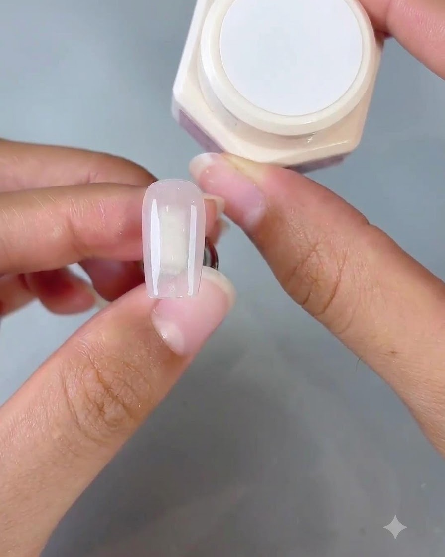 Un applicateur éponge appliquant par tapotements le gel Gentle No. 1 sur le bout de longle pour créer un effet ombré.