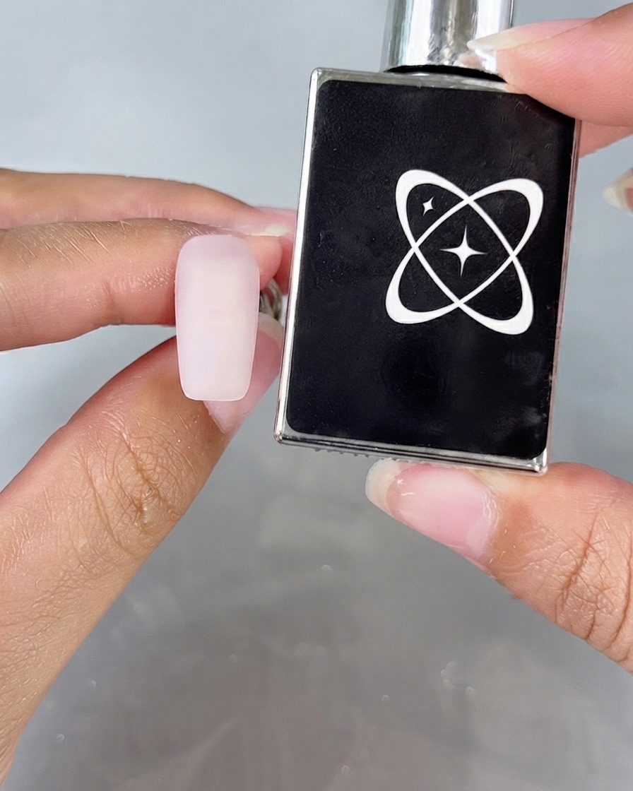 Une surface dongle à laspect mat à côté dun flacon de top coat anti-poudre.