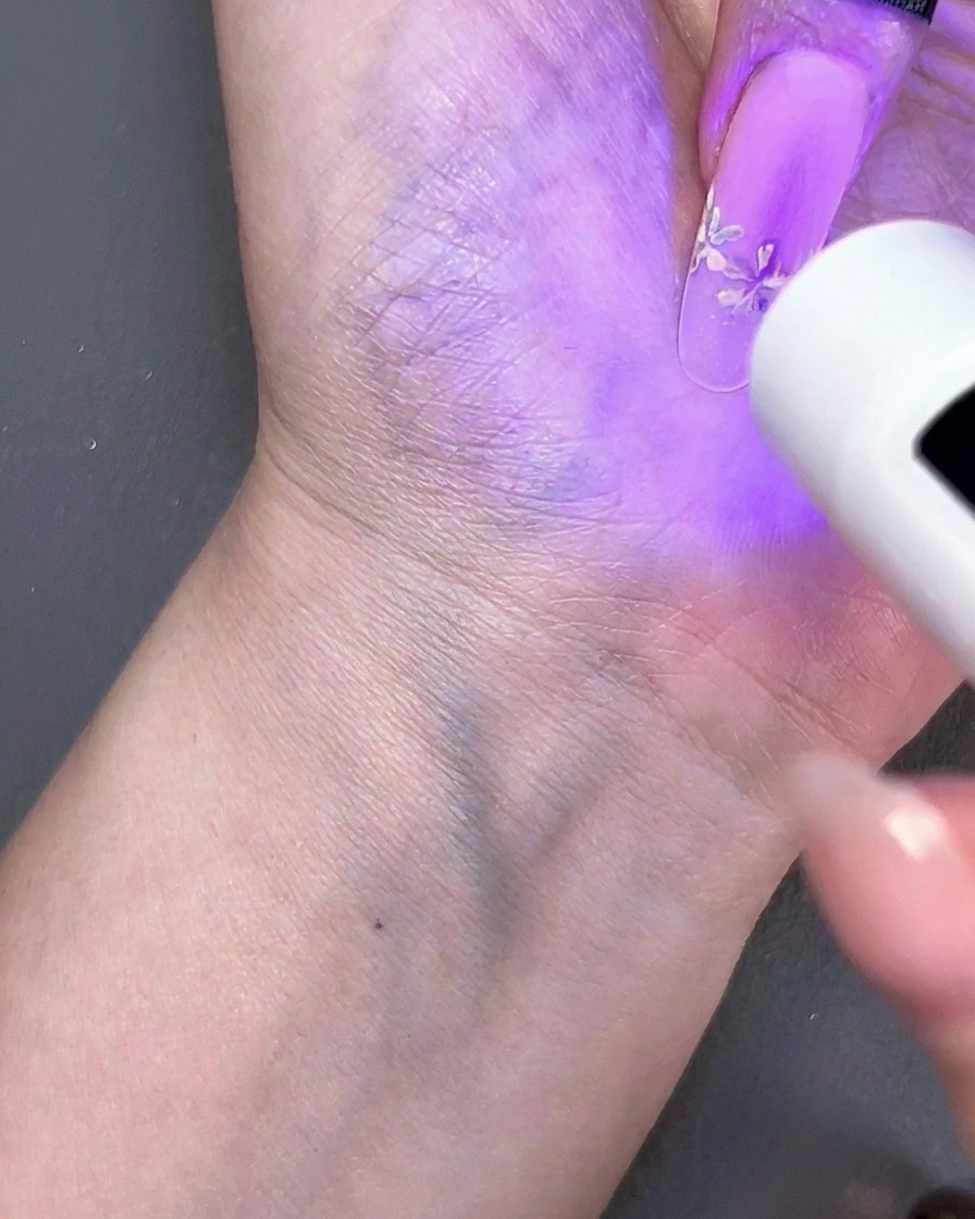 Une mini lampe UV portative catalysant un design dongle floral sous une lumière violette.