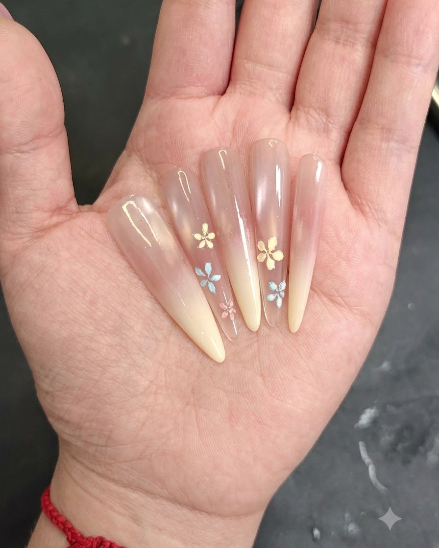Gros plan dune main appliquant du gel blush rose sur le bout dun ongle en amande.