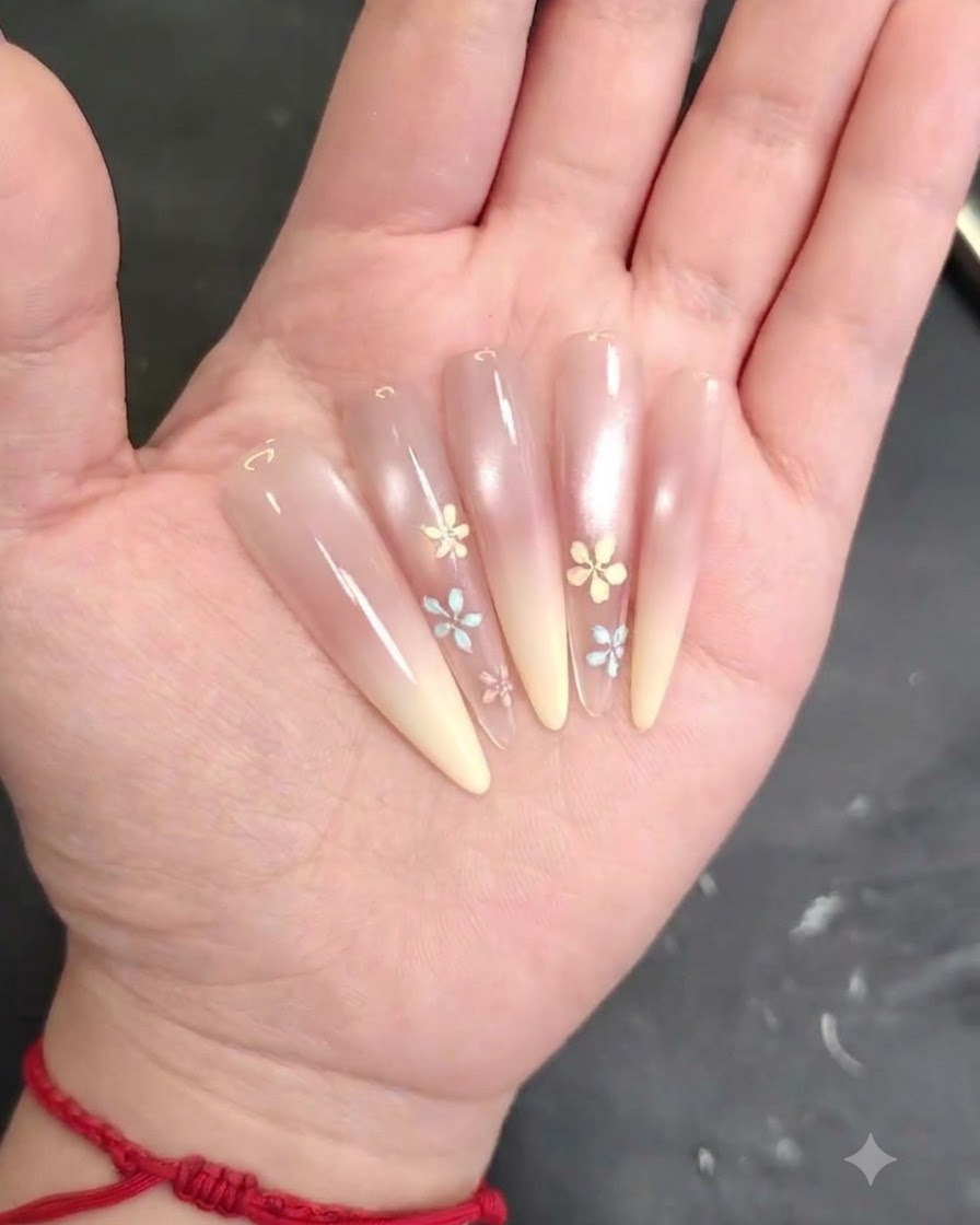Un pinceau à ongle estompant et lissant uniformément le gel blush rose sur la surface de longle.