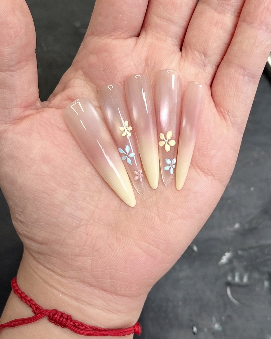 Un pinceau appliquant une couche de top coat transparent sur la surface de longle décoré.