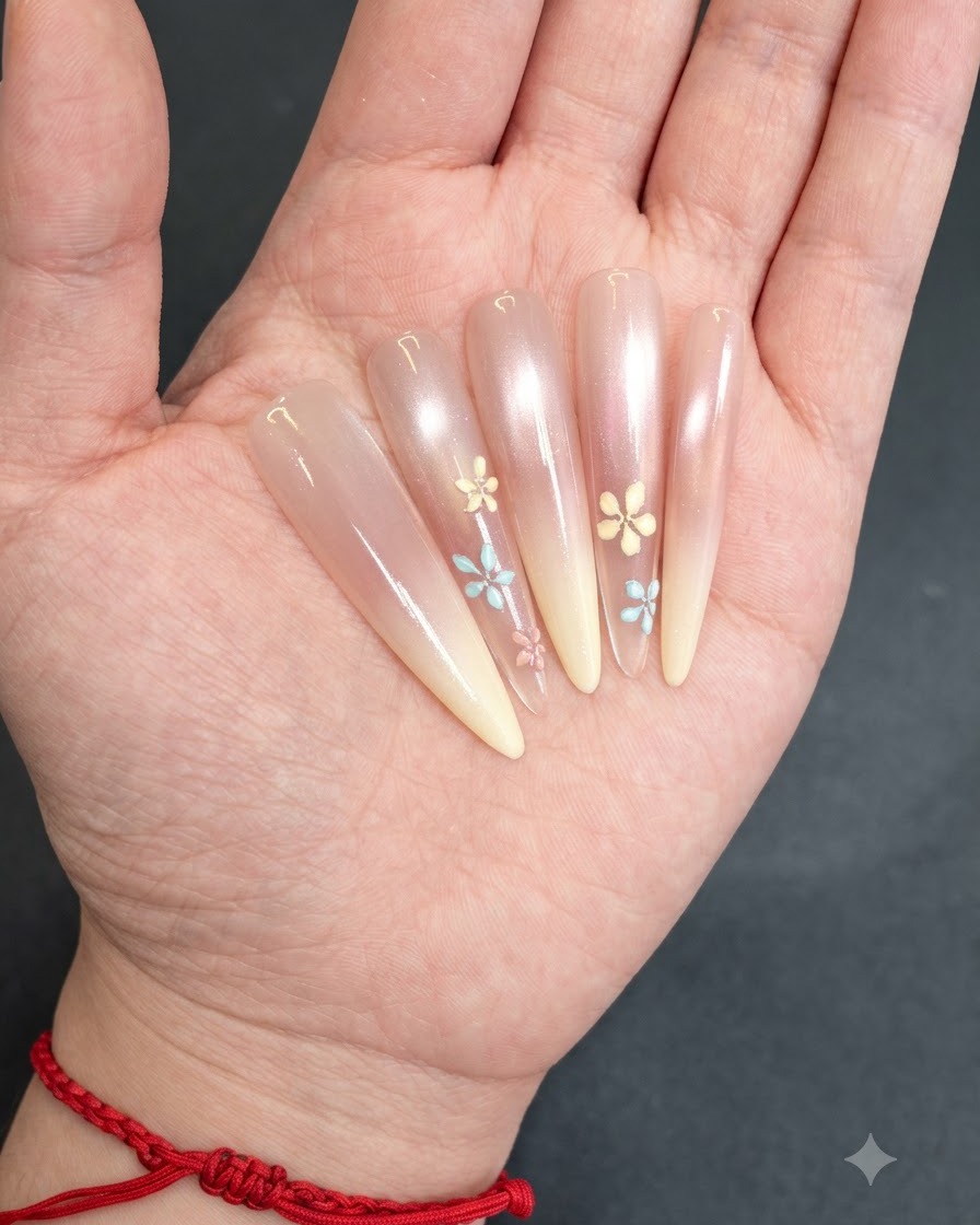 Ongles aux motifs floraux peints à la main en train de catalyser sous une lampe.