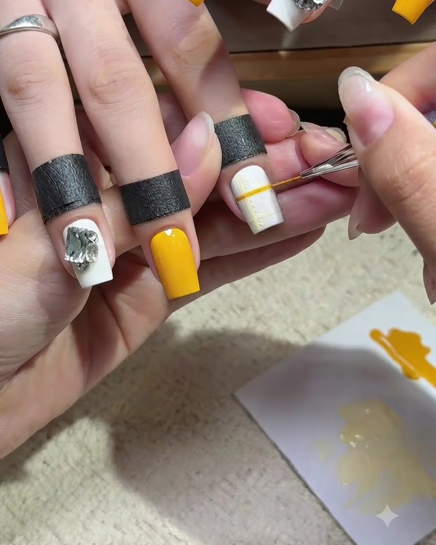 Un pinceau liner fin dessinant une ligne jaune sécante sur une base dongle blanche, complétant un motif de grille à carreaux jaunes délicat.