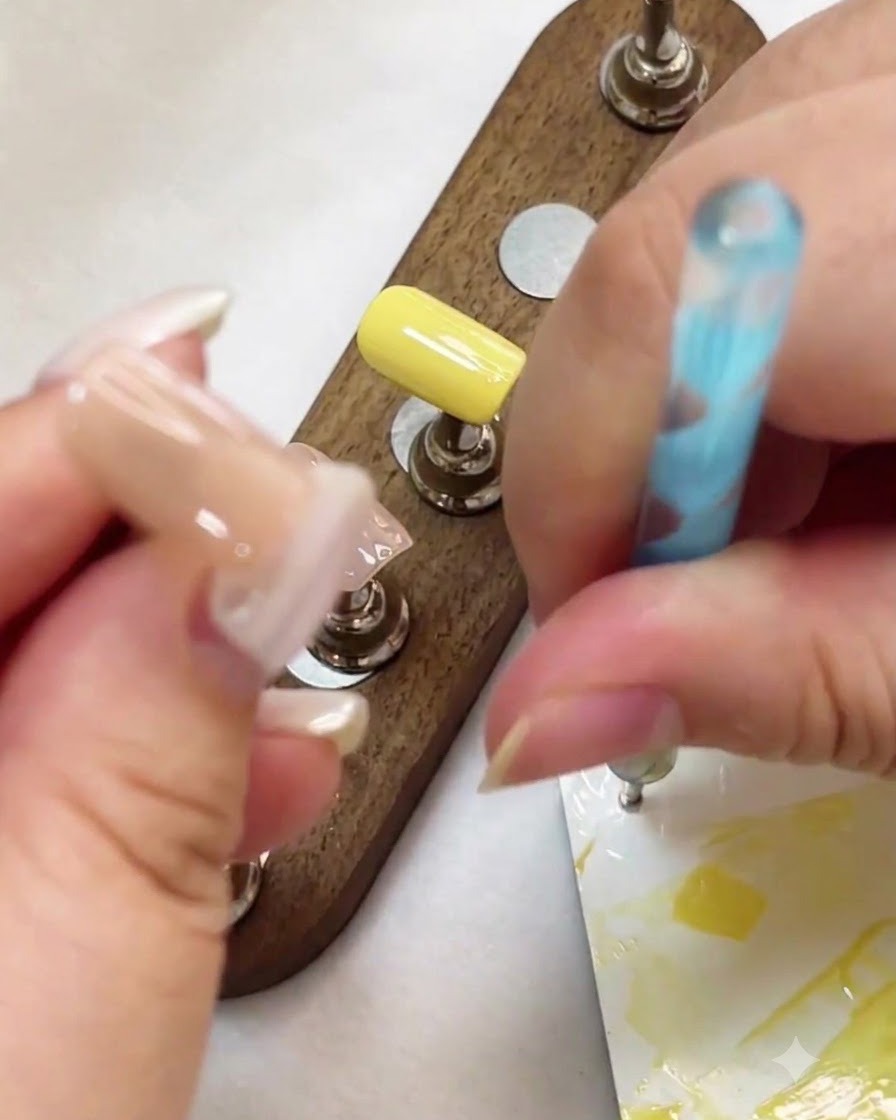 Un dotting tool utilisé pour placer des points de gel blanc sur une surface dongle nude.