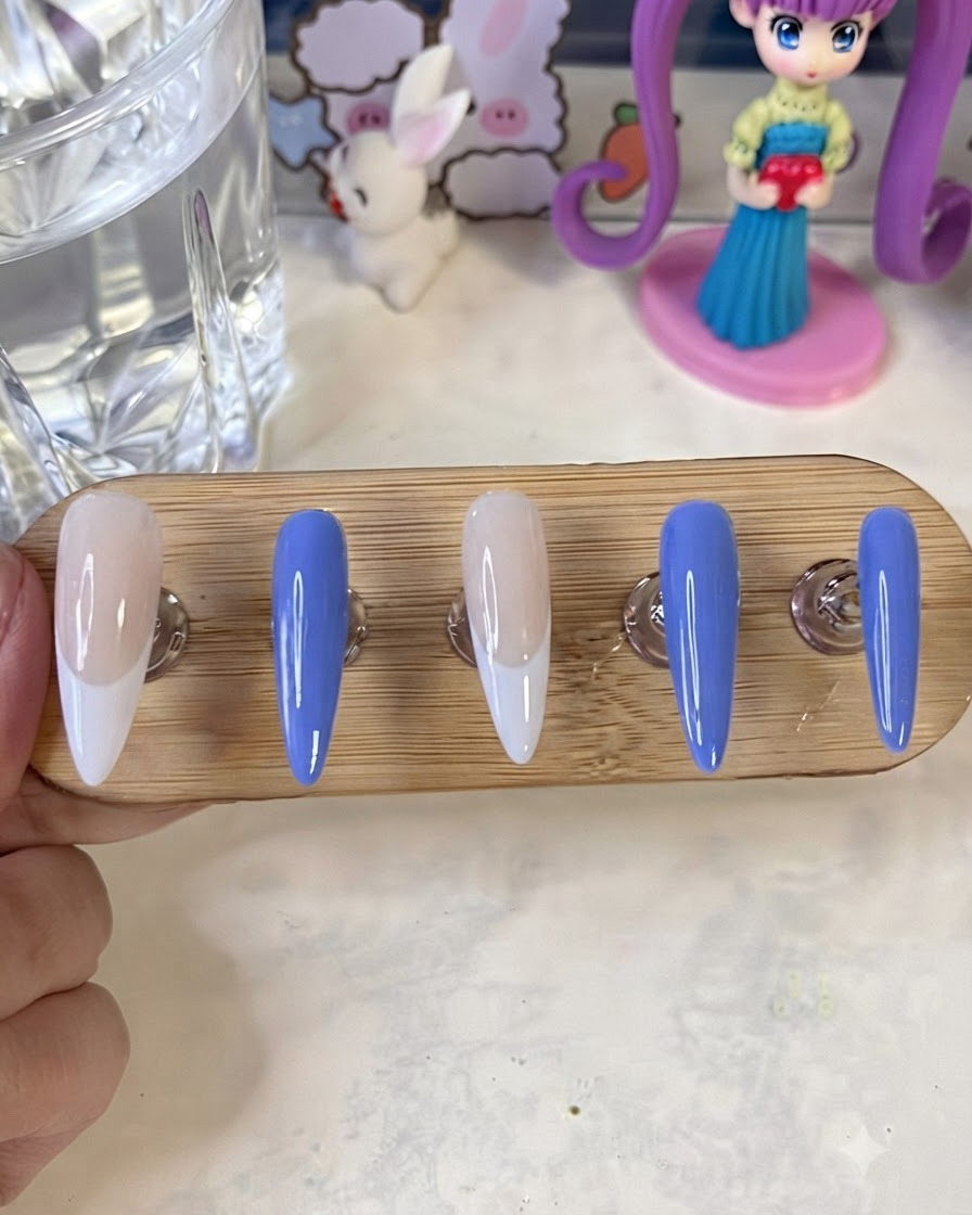 Des supports à ongles avec des ongles peints finis assis sous une lampe de catalysation UV/LED.