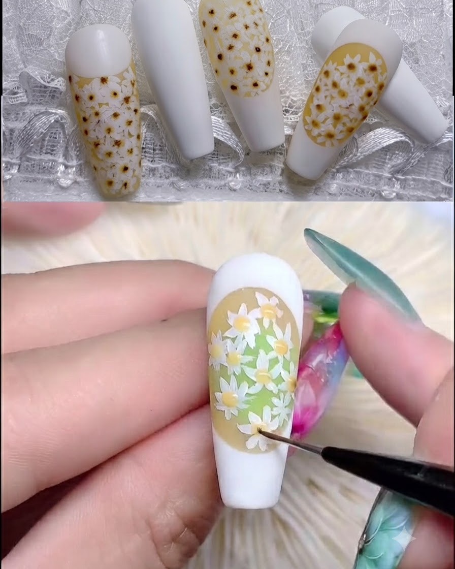 Un pinceau à ongles appliquant un rubber top coat transparent sur un motif de marguerite texturé.