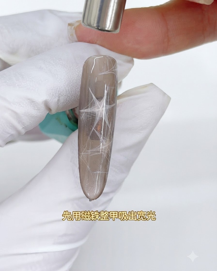 Un aimant cylindrique surplombant un ongle cat eye brun pour attirer une large bande de lumière réfléchissante.