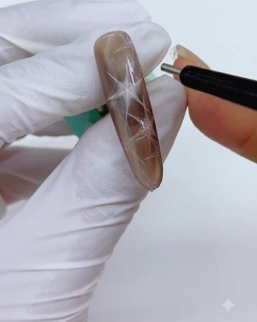 Un outil stylo magnétique cylindrique fin maintenu près de longle pour affiner les bords de la forme triangulaire magnétique.