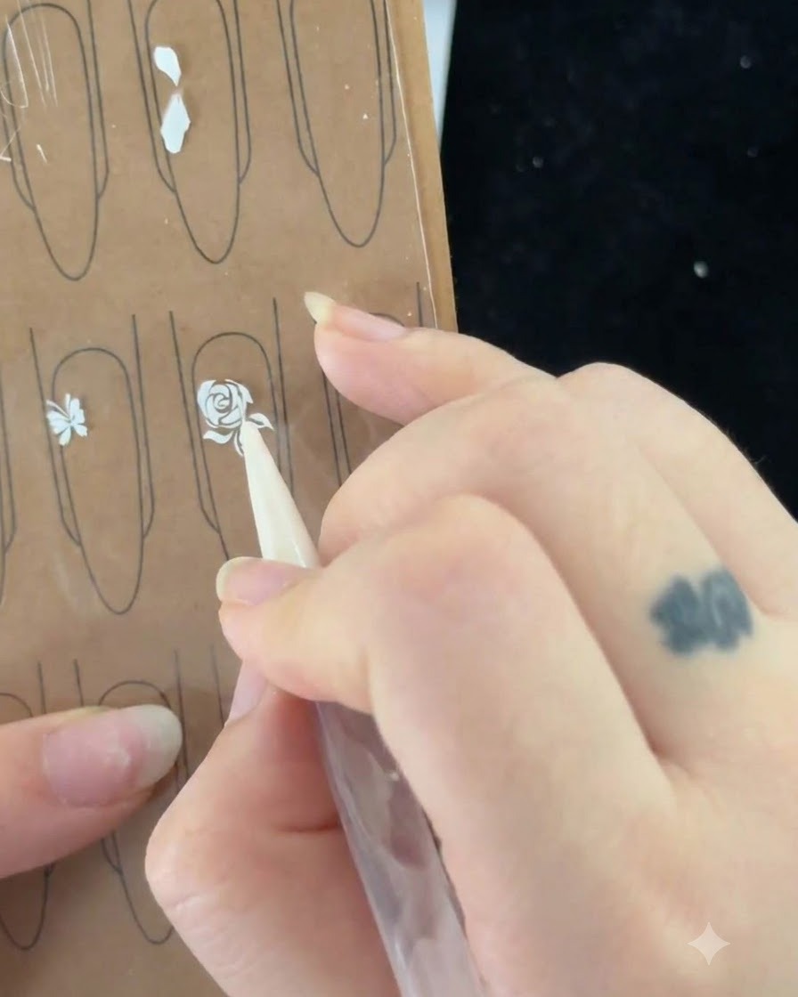 Un pinceau à ongles tirant une fine ligne pour commencer à peindre une feuille à côté de la rosecite: 1.