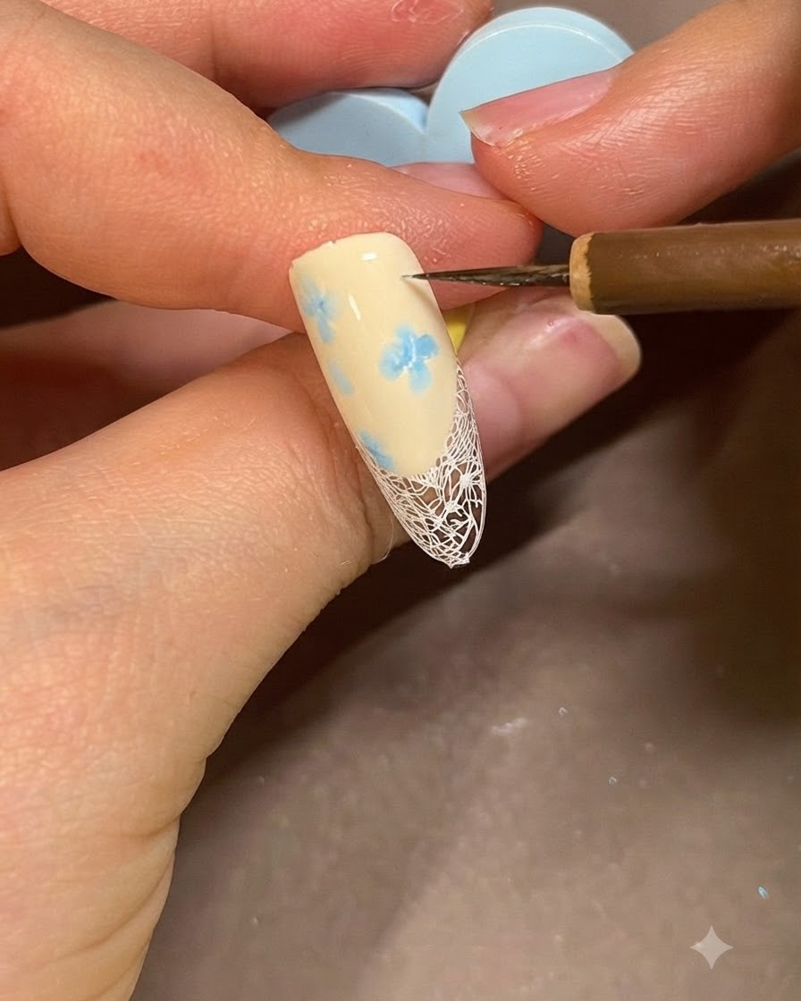 Un pinceau appliquant du gel de construction transparent sur un ongle décoré pour lisser et protéger le design.