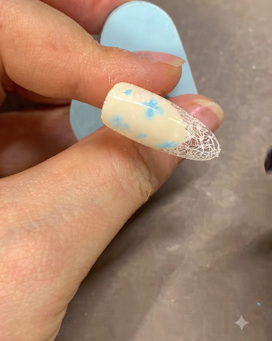 Un pinceau fin appliquant une ligne de gel blanc nette le long du bord de la french manucure.