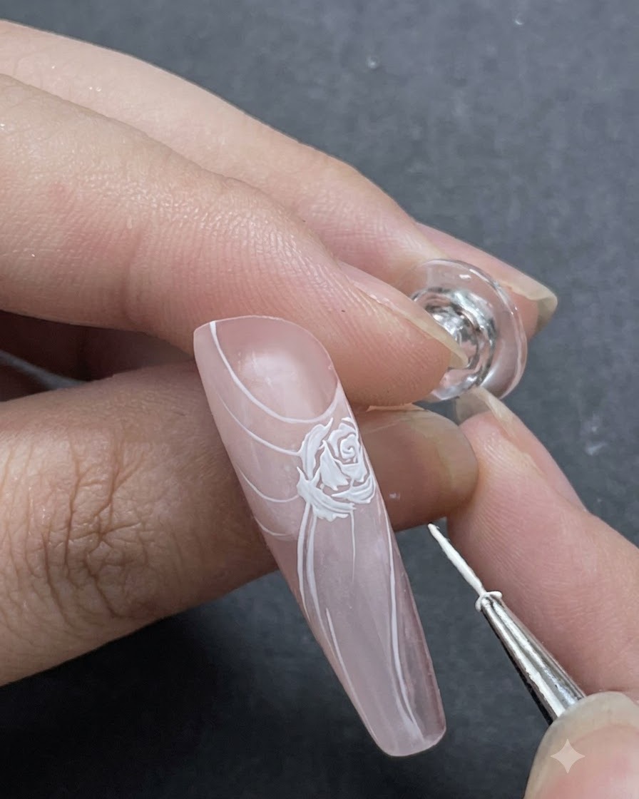 Un plan rapproché montrant de fins accents de pétales blancs ajoutés autour du design de rose principal avec un pinceau liner.