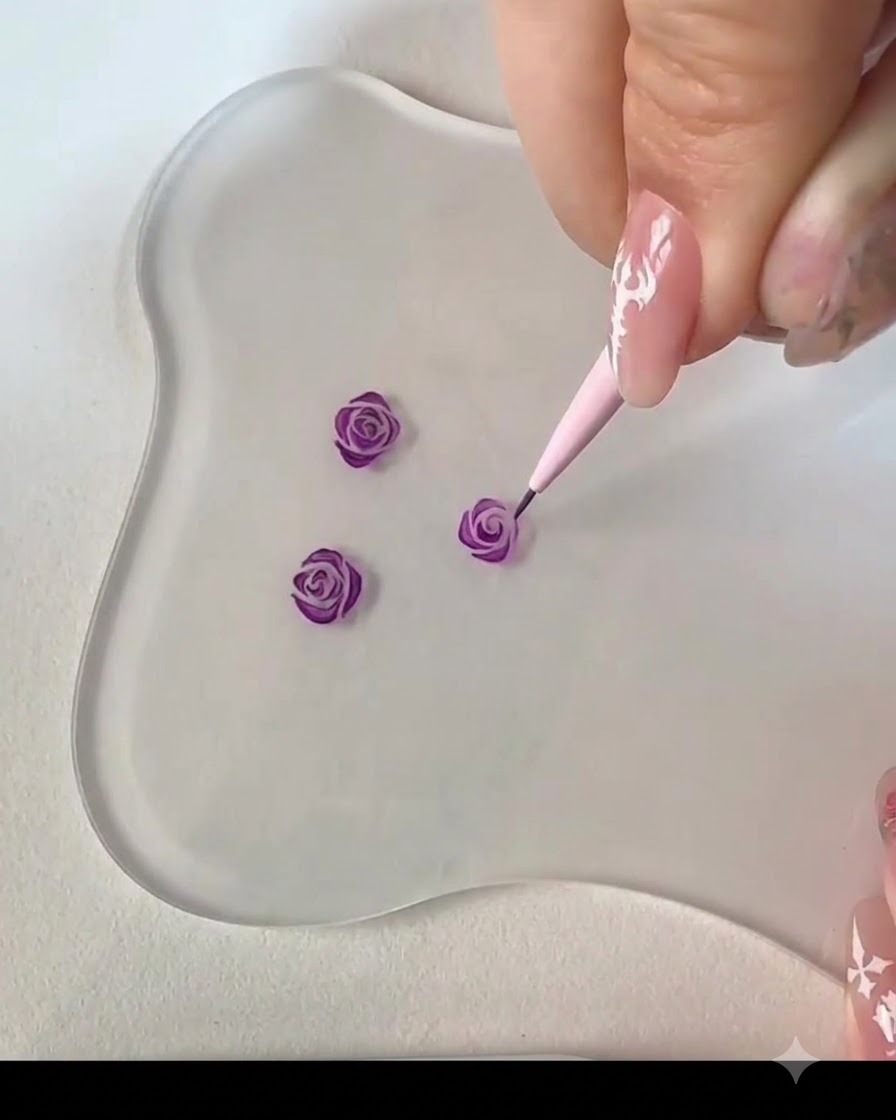 Un pinceau liner fin ajoutant un trait courbé adjacent pour compléter le centre du bouton de rose violette.