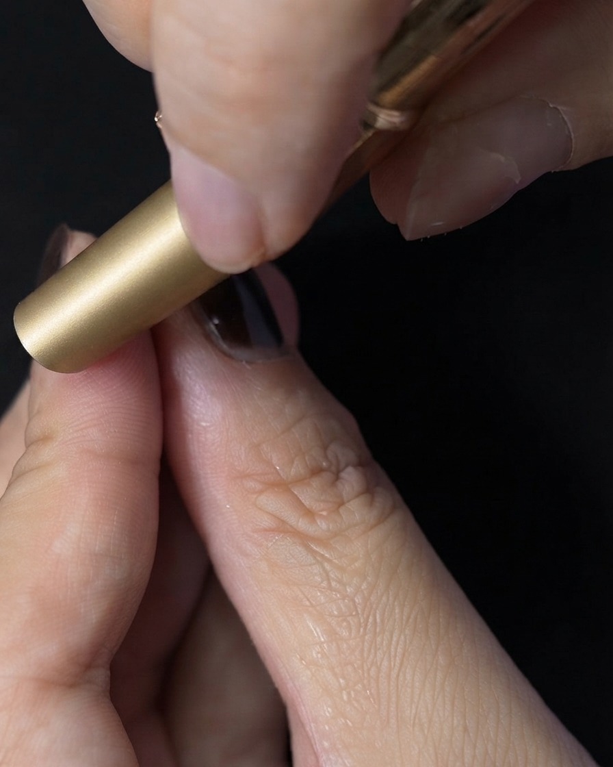 Un ongle placé à lintérieur dune mini lampe UV LED pour catalyser le top coat.