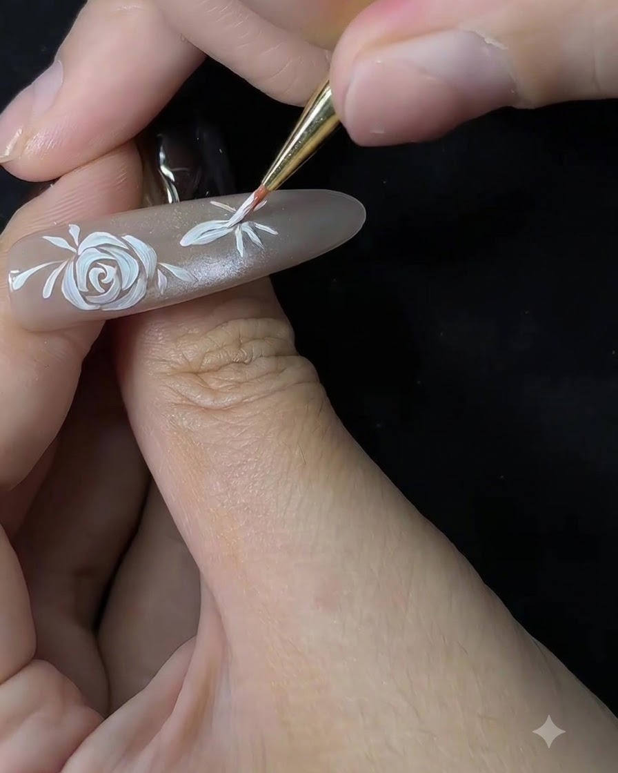 Gros plan dun pinceau fin commençant à façonner les pétales dune fleur secondaire sur une extension dongle nude.