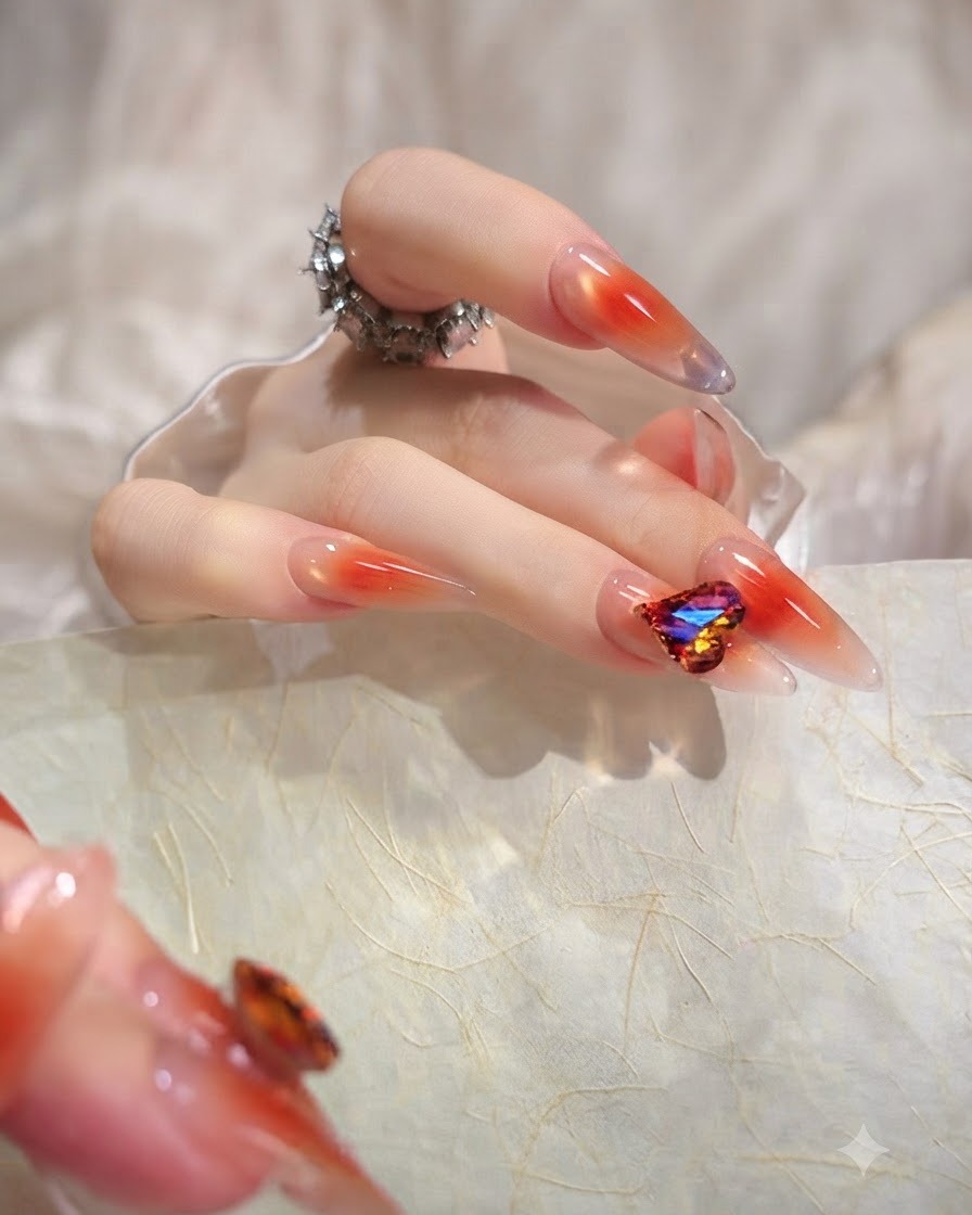 Gros plan dun pouce mettant en valeur un long ongle en amande avec un dégradé orange translucide uniforme.