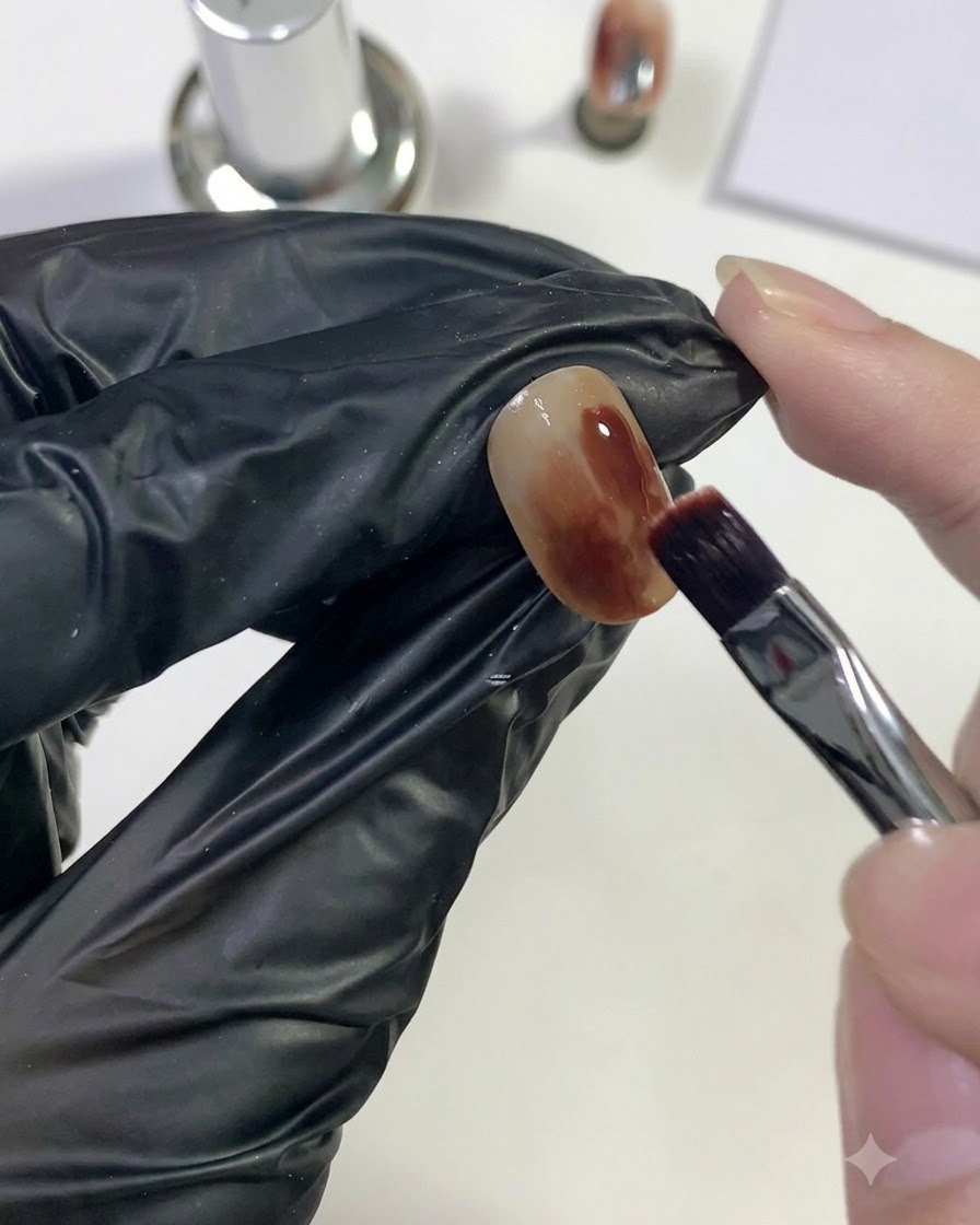 Un pinceau appliquant du gel rouge profond sur une zone localisée de longle.