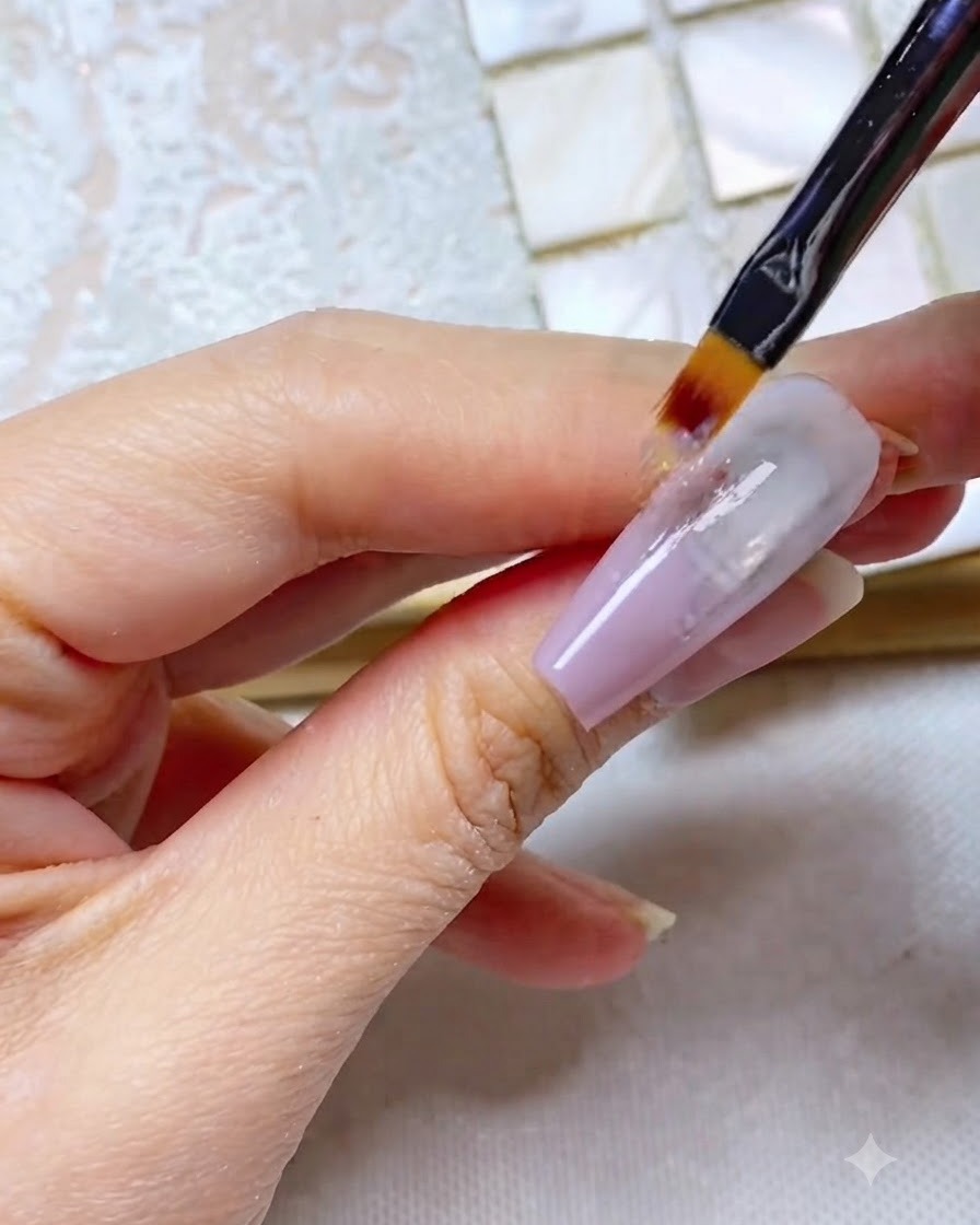 Un pinceau ombré tirant le gel gris-violet tout droit le long de longle, créant un aspect strié.