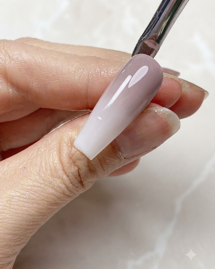Du gel blanc laiteux translucide appliqué sur le bord libre dun ongle en dégradé.