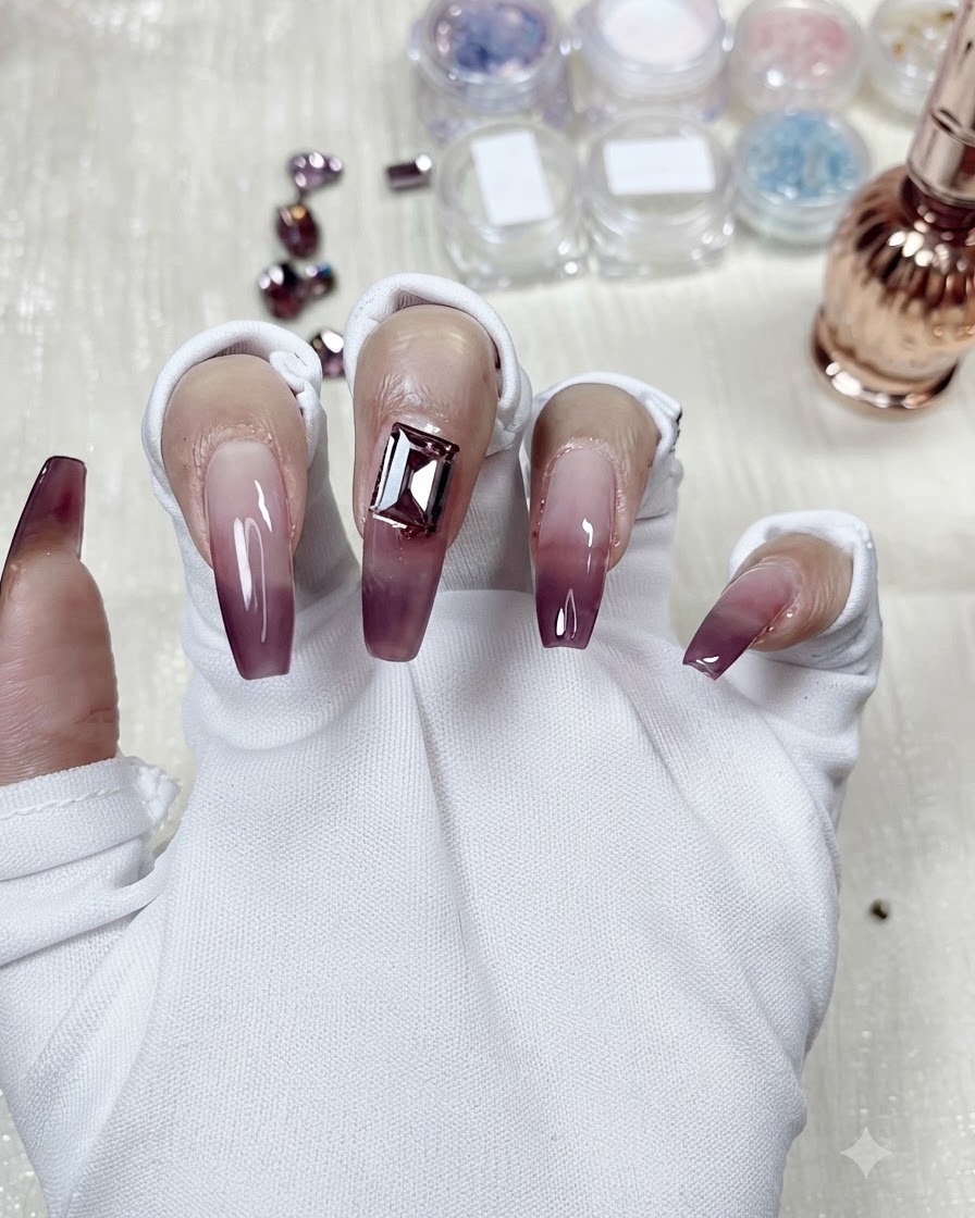 Un cristal rectangulaire placé au centre dun ongle en dégradé violet taro pour comparer le design.