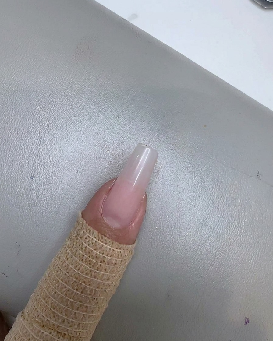 Un ongle avec un doux effet de dégradé rose sestompant vers la zone de la cuticule.