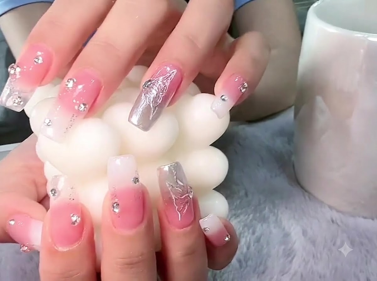 Mains tenant une bougie pilier blanche texturée avec un accent sur le nail art papillon en argent 3D.