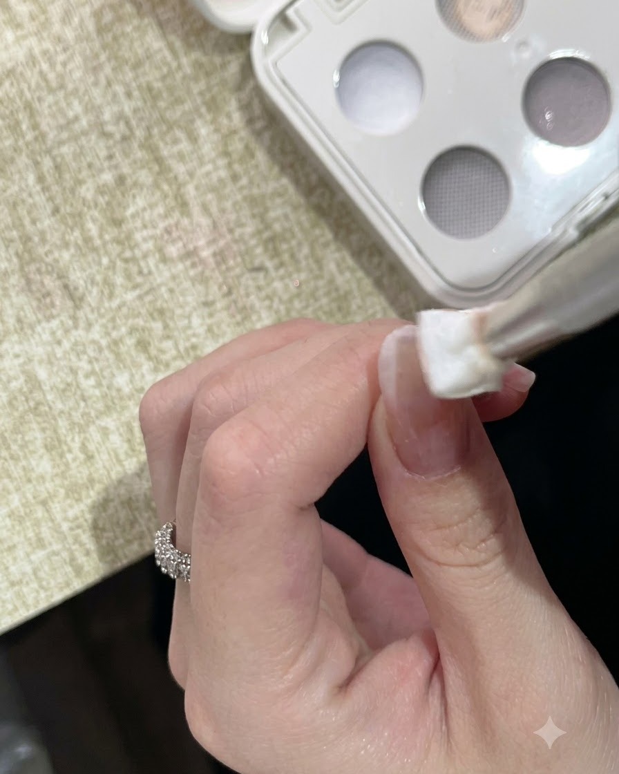 Un outil éponge appliquant par touches du gel dargile solide blanc sur le bout dun ongle manucuré.