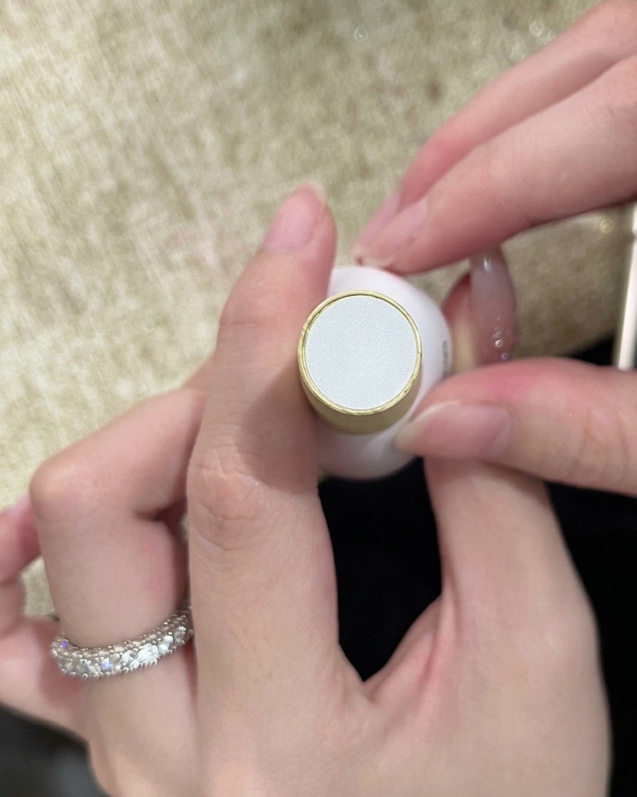 Un flacon de top coat transparent tenu en main, prêt à sceller le nail art terminé.