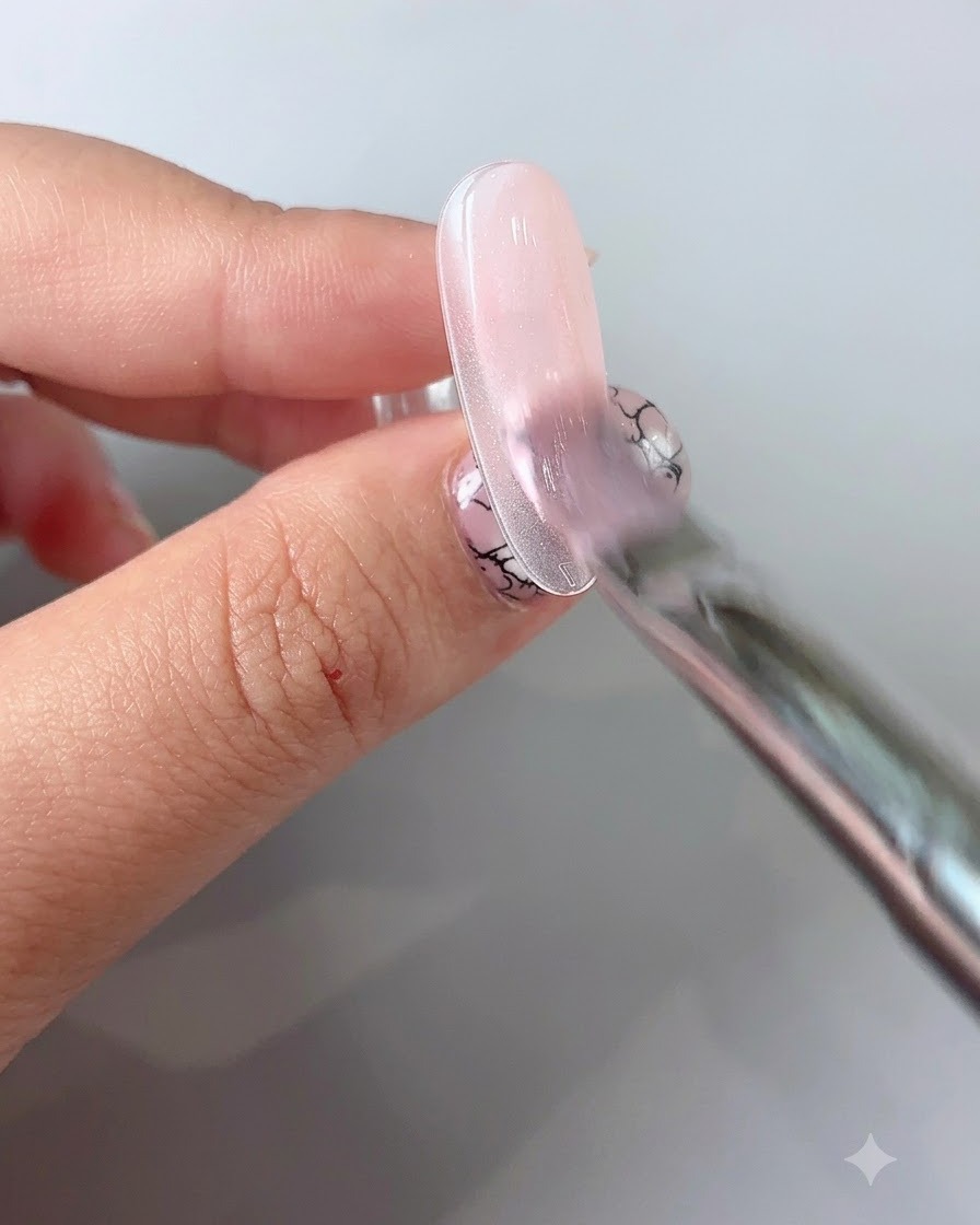 Un pinceau liner fin dessinant de fines lignes délicates sur un ongle vernis en gel.