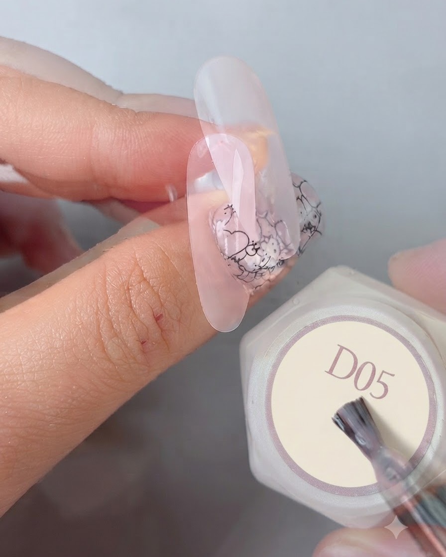 Un pinceau de manucure appliquant un top coat lisse et brillant final sur un design dongle complété à côté dun flacon de gel étiqueté D05.