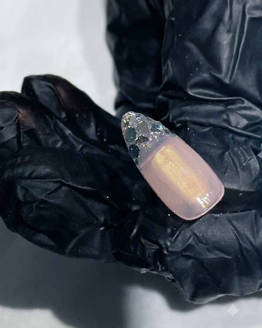 Un gros plan dun ongle avec un gel de renforcement lisse encapsulant la pointe pailletée.