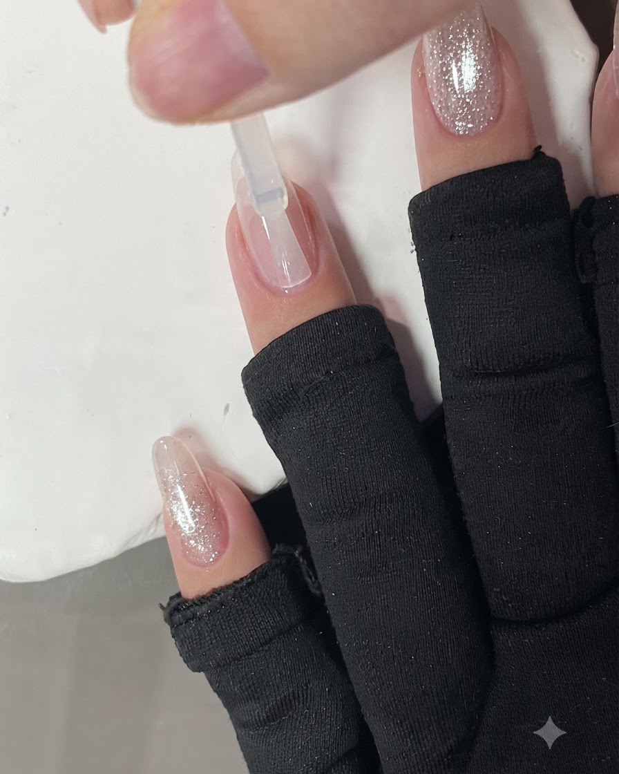Application dune base transparente sur un ongle à laide dun pinceau.