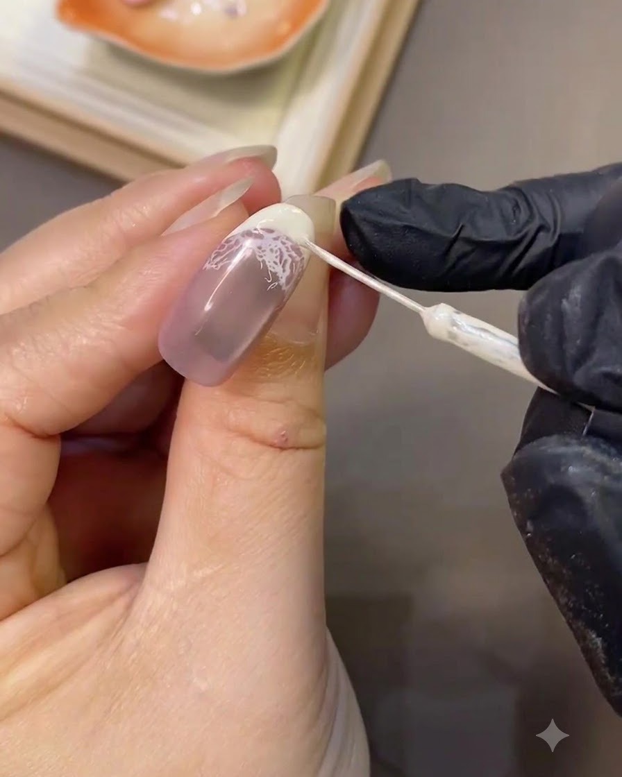 Un pinceau liner fin affinant avec précision la courbe blanche nette dune french sur un ongle manucuré.
