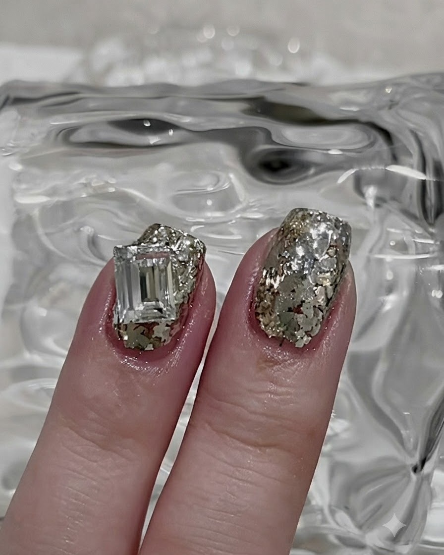 Pinceau fin pour nail art prélevant une petite portion de poudre de paillettes argentées libre.