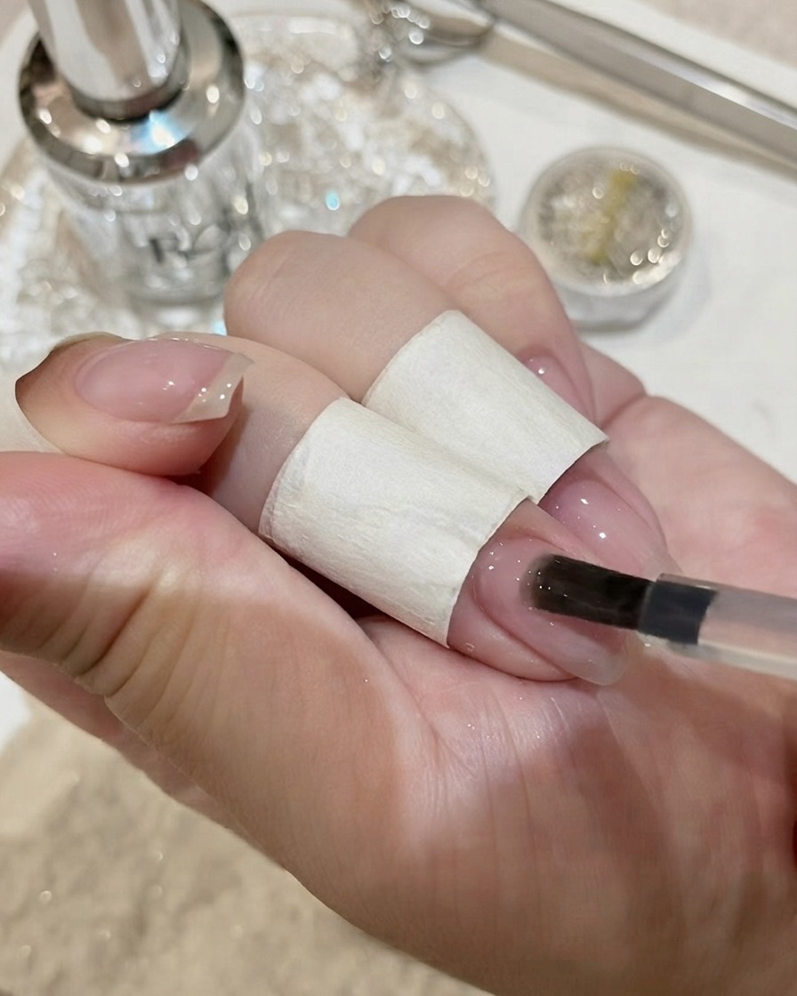 Ongles avec un grand cristal gemme catalysant sous une lampe UV.
