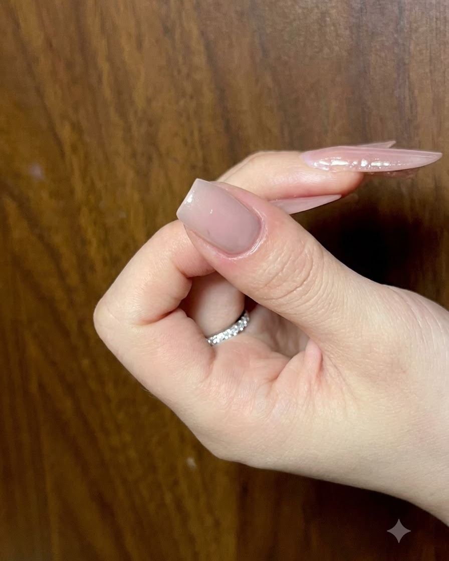 Gros plan dun ongle nude manucuré recevant des traits de gel œil-de-chat détaillés pour lart des ailes de papillon.