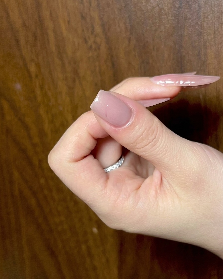 Gros plan de gel noir utilisé pour tracer les formes dailes dun design de nœud sur un ongle.