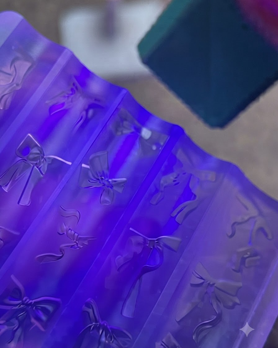 Un moule à ongle en silicone violet contenant des nœuds en gel transparent placés sous une lampe UV lumineuse.