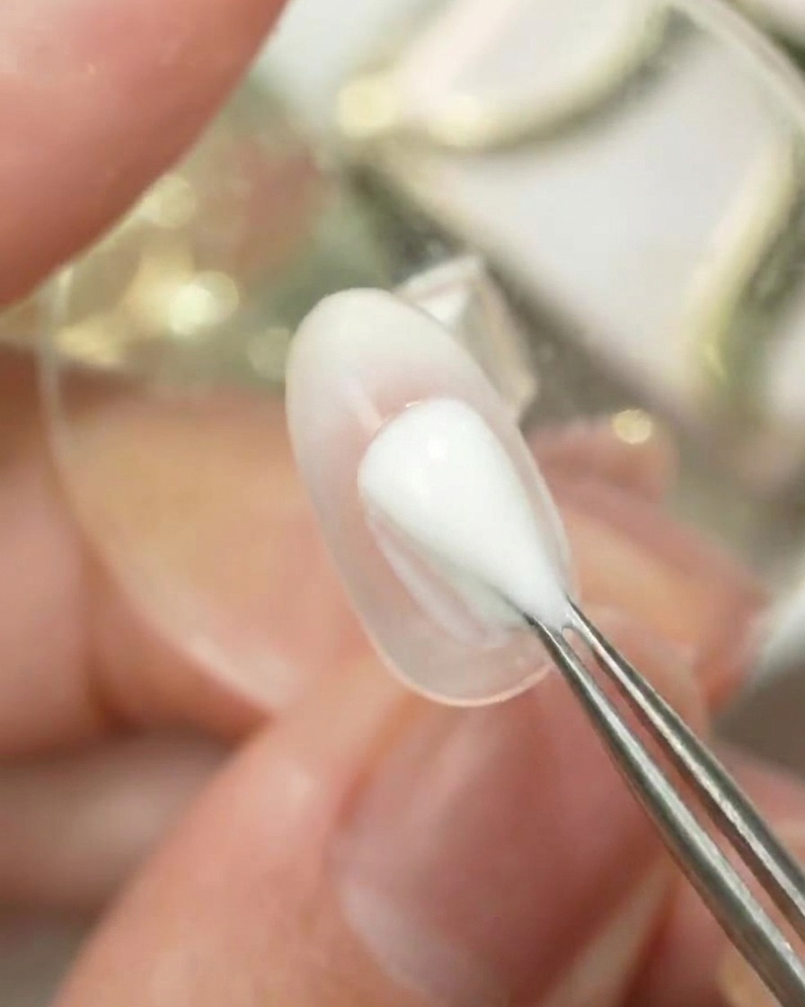 Un outil appliquant par tapotements la couleur Gulauri numéro 6 sur une surface dongle transparente pour créer un dégradé ombré.