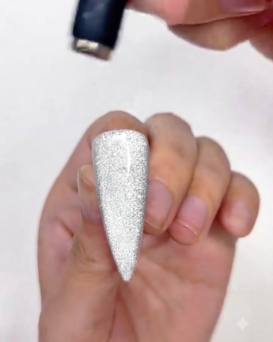Un aimant ajustant la partie supérieure du vernis gel cat-eye sur longle.