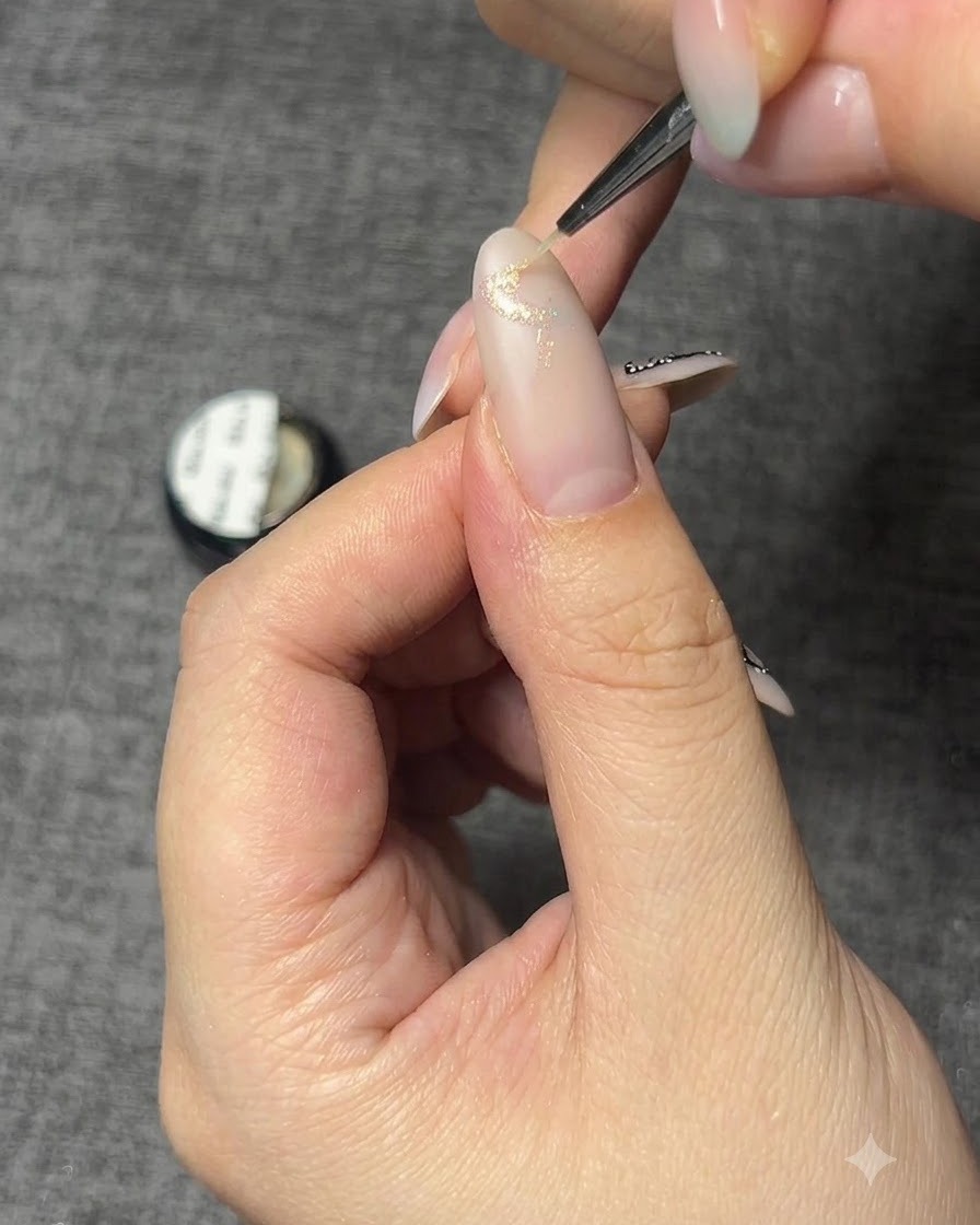 Gros plan sur un ongle avec un contour de papillon en gel scintillant.
