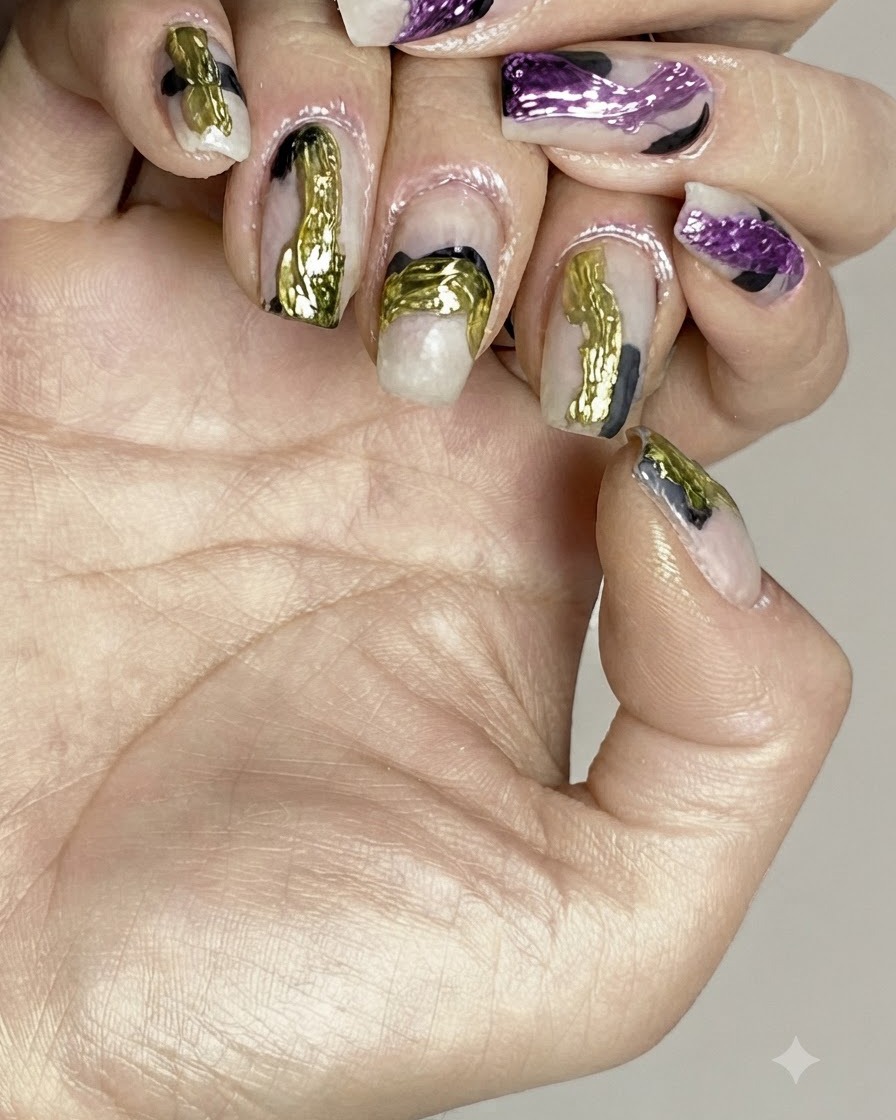 Un pinceau appliquant un top coat transparent et brillant sur un nail art abstrait terminé.