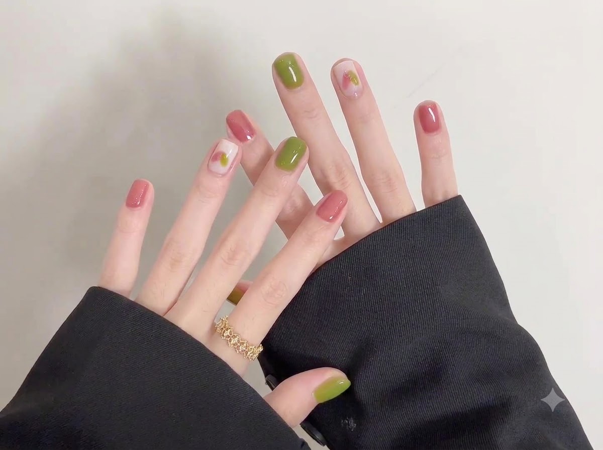 Un plan rapproché mettant en valeur des illustrations doodle complexes créées sur une base douce et claire sur des ongles courts.