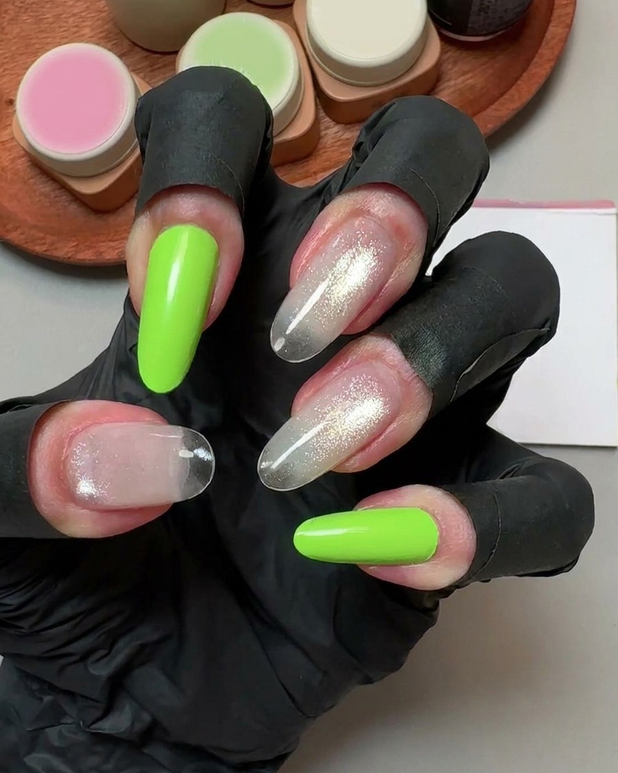 Une main portant des gants noirs tenant un coton nettoyant sur de faux ongles catalysés.