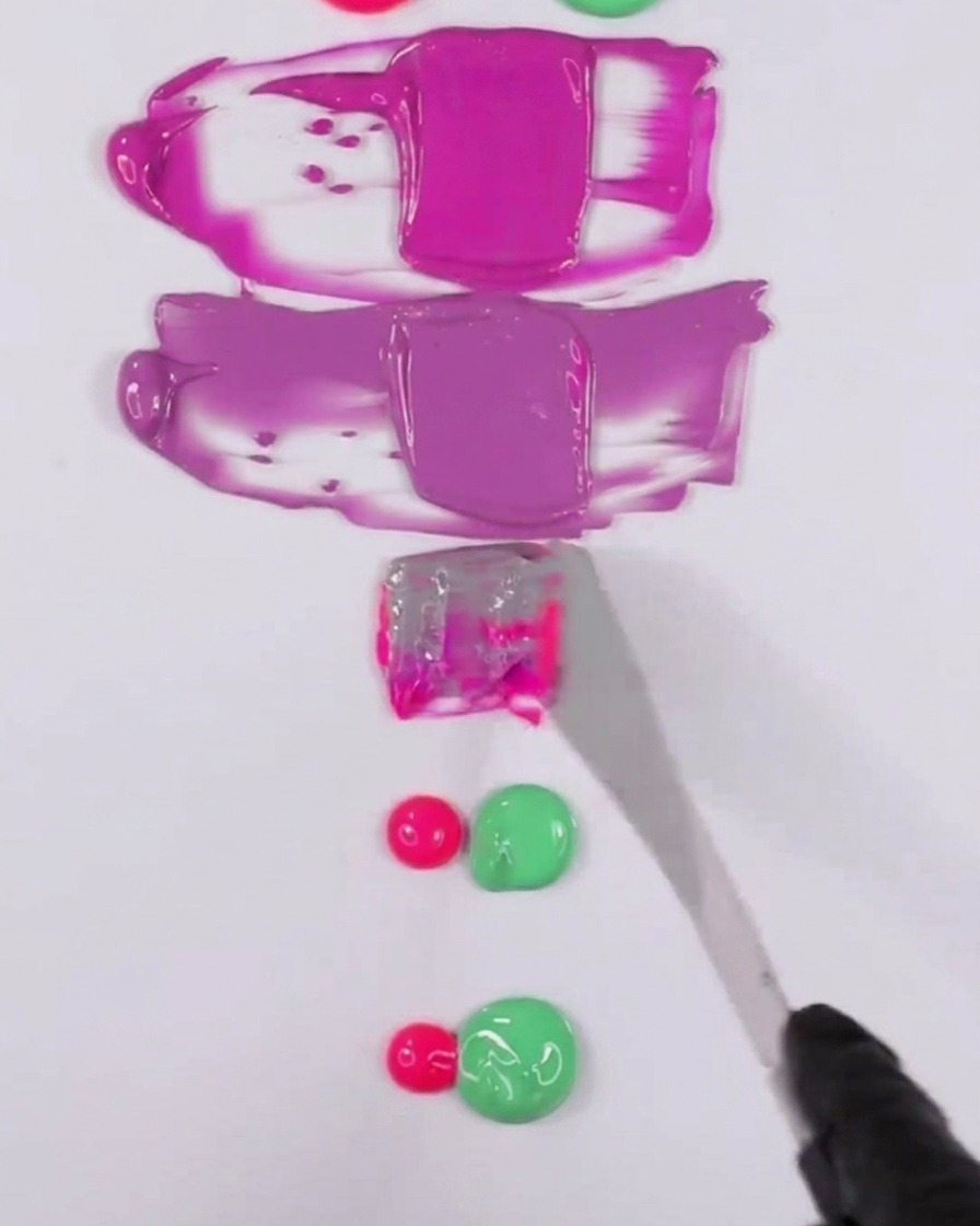 Une spatule en metal melangeant un melange de vernis gel rose et vert pour creer un ton violet doucement fane.