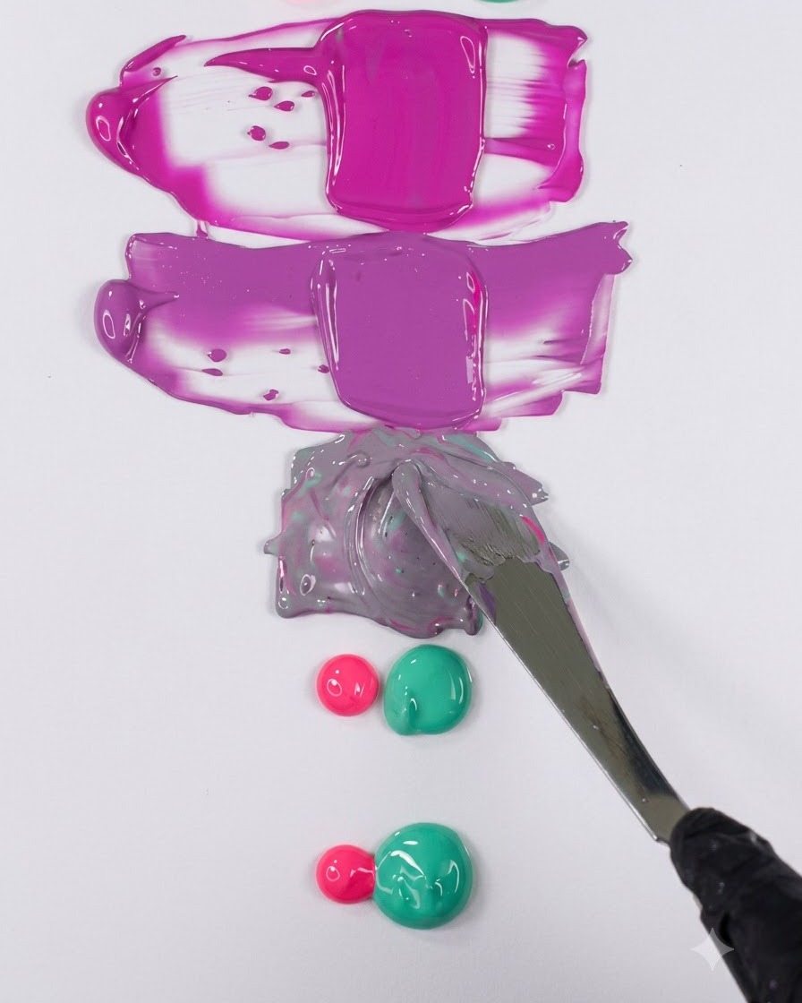 Une spatule en metal lissant un melange de gel violet nuance en un echantillon horizontal propre sur une surface blanche.