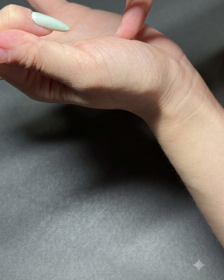 Un pinceau fin appliquant du vernis gel vert menthe clair sur un ongle.