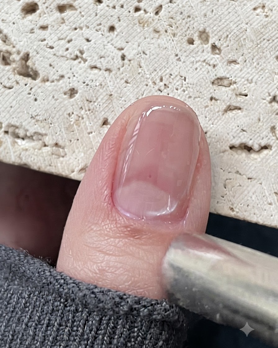 Un outil aimanté positionné près dun ongle en gel cat eye brillant pour attirer les particules magnétiques.